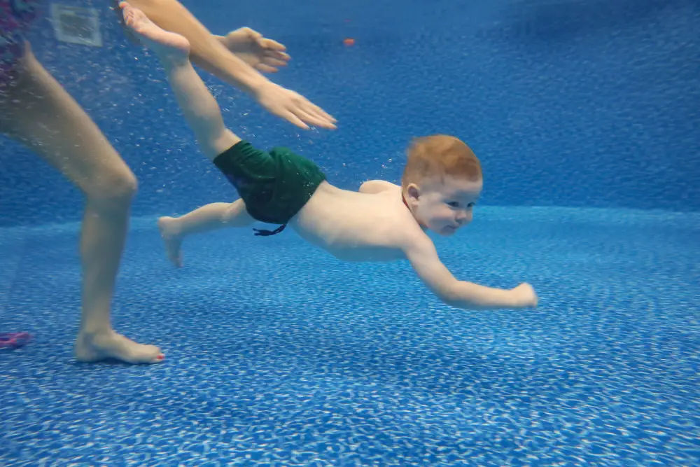 Parent & Me (Ratio 1_8) – Under 3 Years Old Baby boy dives underwater in the pool with pleasure